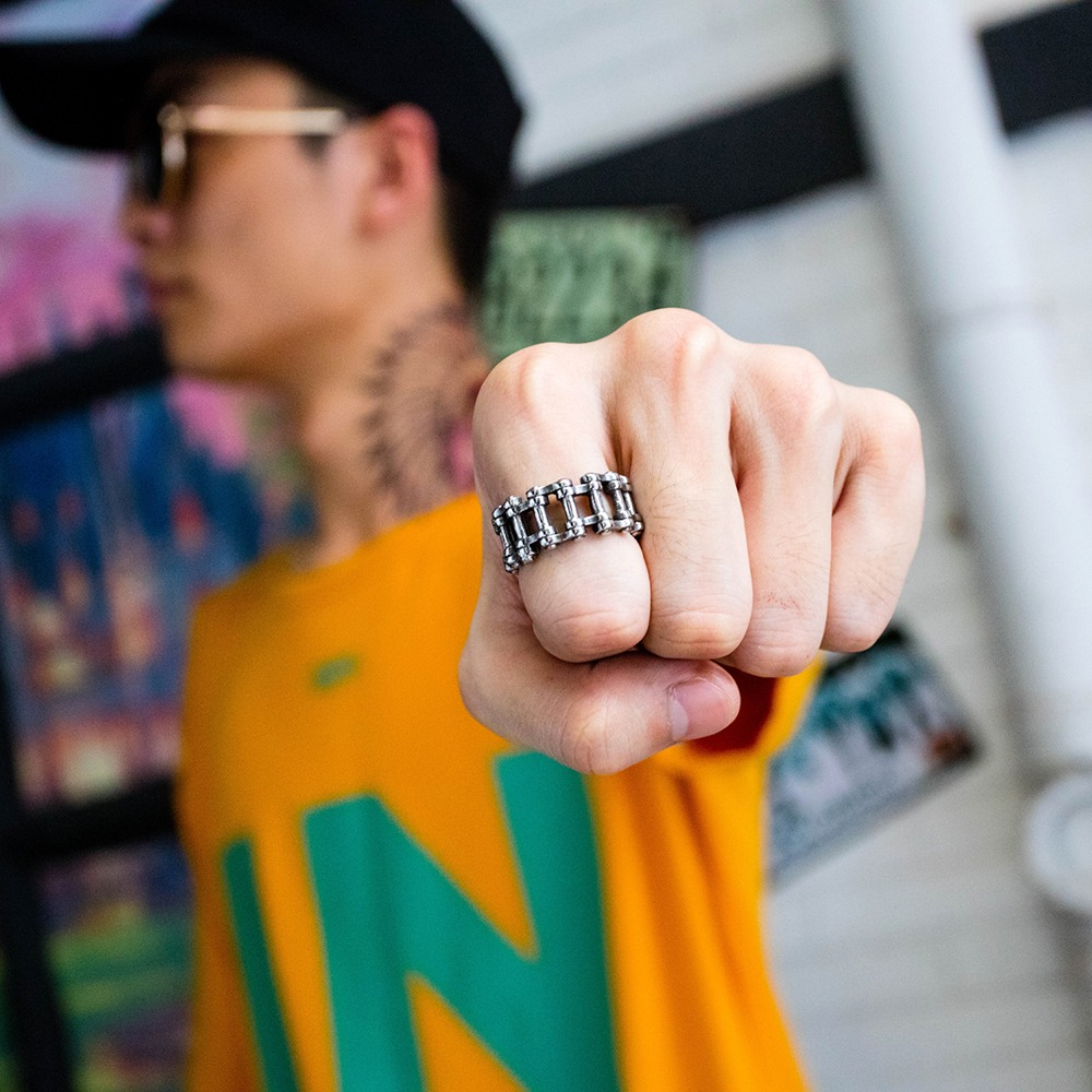 Biker's stainless steel chain ring worn by a person, showcasing punk rock style and unisex appeal.