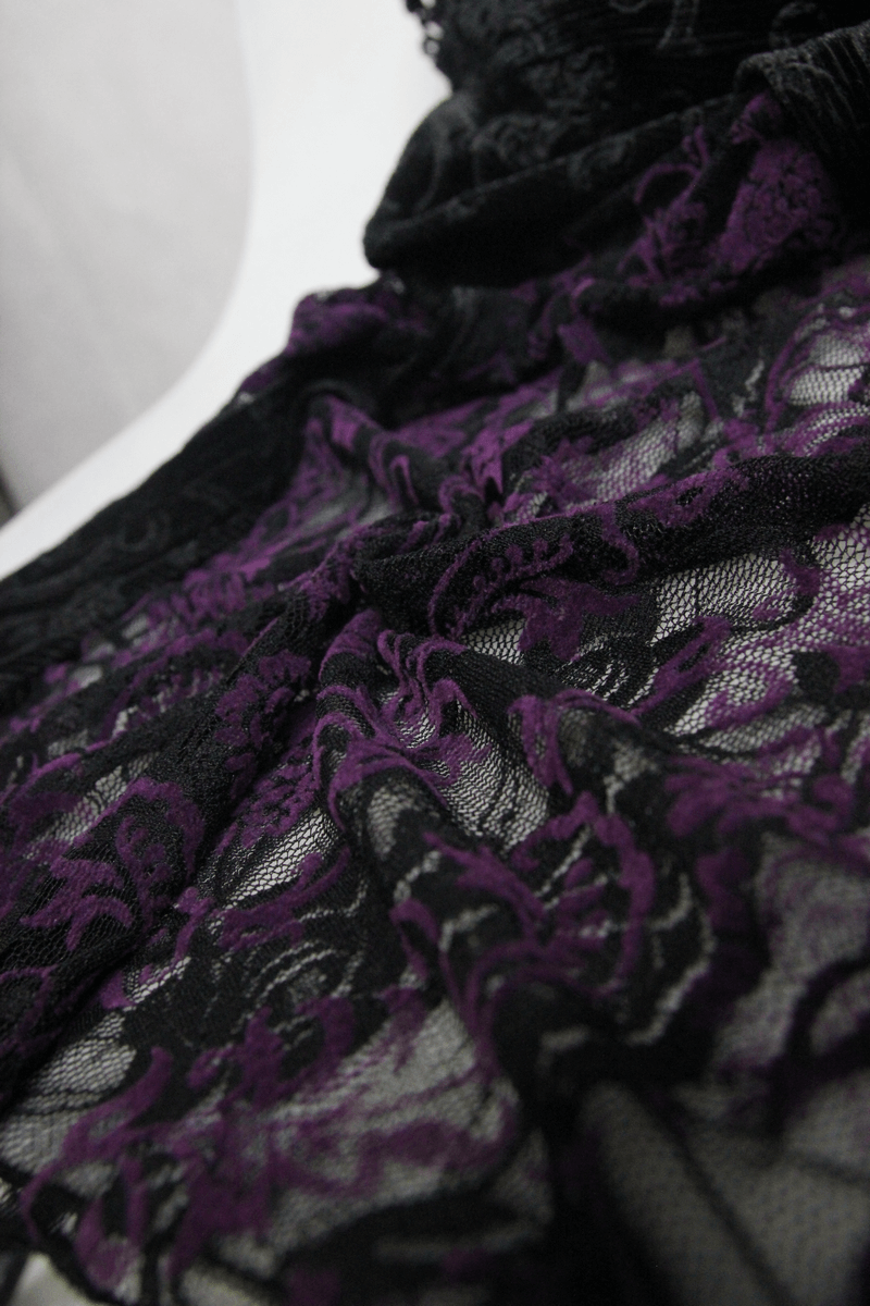Close-up of elegant black and purple lace fabric, showcasing intricate gothic design and decorative roses.