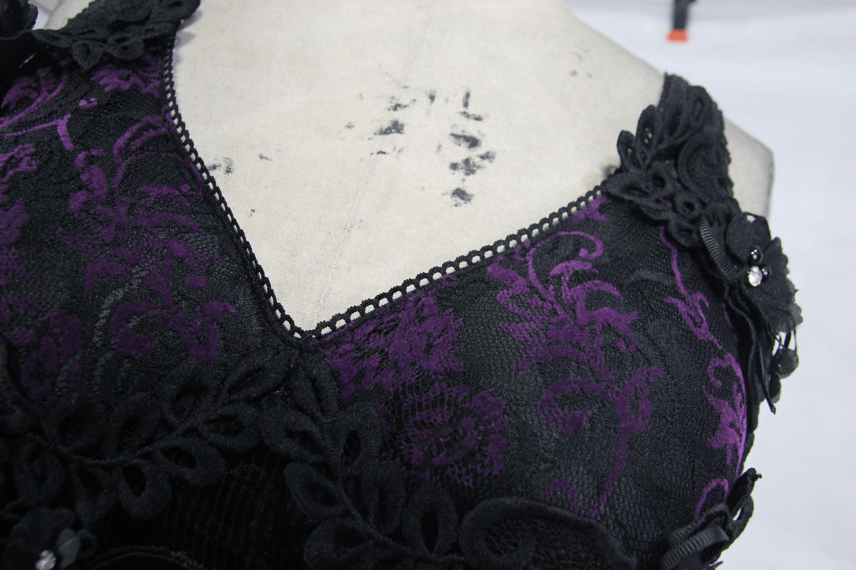 Close-up of a black and purple gothic lace dress featuring elegant floral patterns and decorative lace trim.