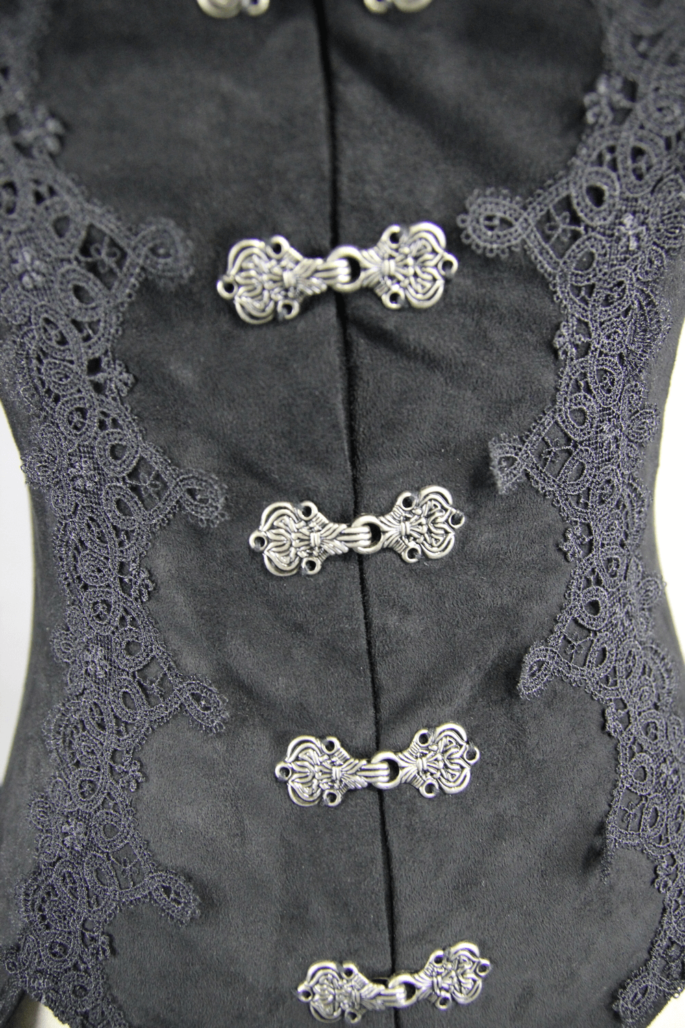 Close-up of black Gothic long coat detailing, featuring intricate lace and silver button embellishments.
