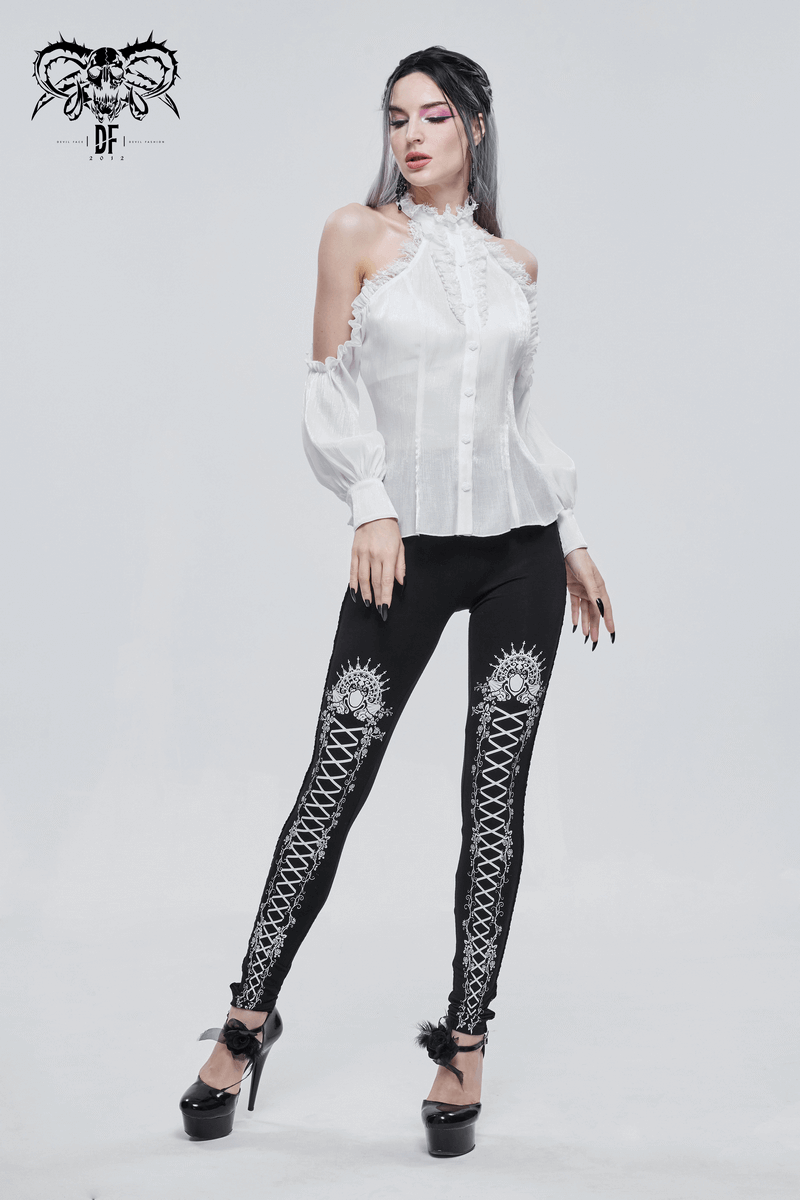 Stylish woman wearing black gothic leggings with intricate prints, paired with a white ruffled blouse and high heels.
