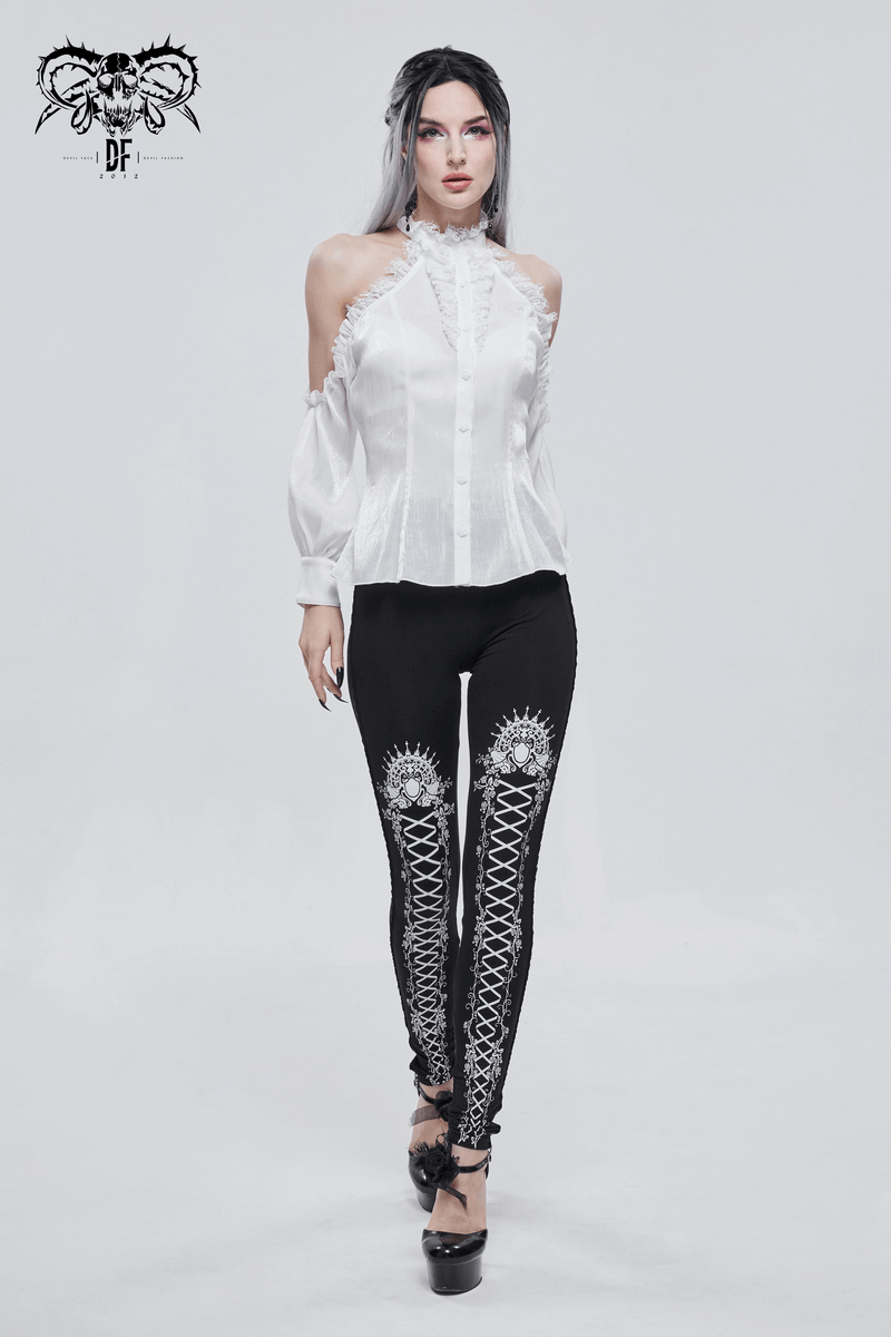 Stylish model in gothic black leggings with unique lacing pattern and white blouse, showcasing modern gothic fashion.