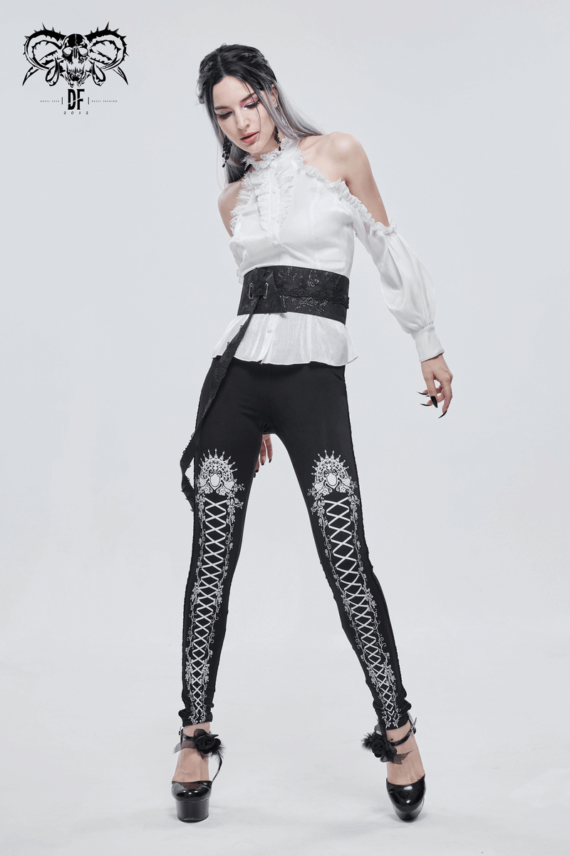 Stylish model wearing black gothic leggings with intricate lacing pattern and a chic white blouse.