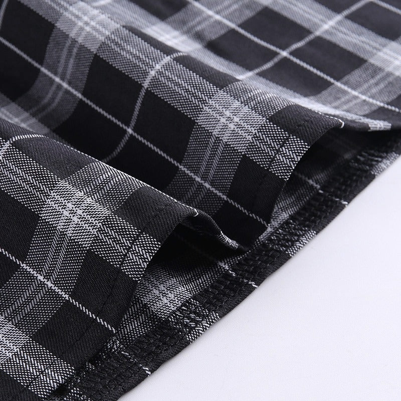 Close-up of black and white plaid fabric, showcasing the pattern for a women's mini dress, perfect for grunge outfits.