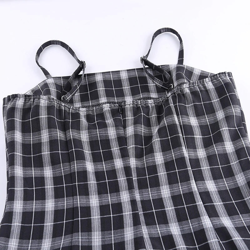 Close-up of a black and white plaid sleeveless mini dress showing neckline and shoulder straps.