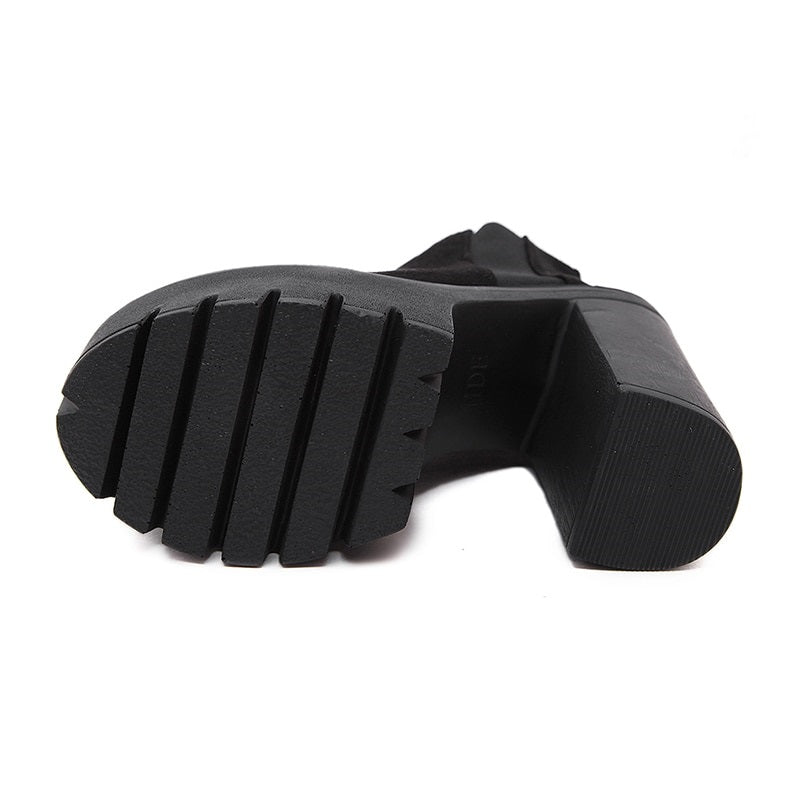 Sole view of stylish black ankle boots for women with thick heels and rubber traction, perfect for all seasons.
