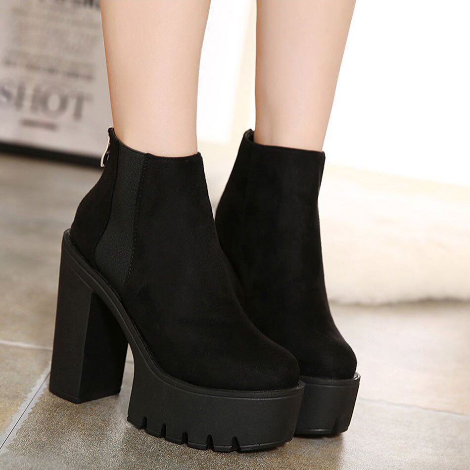 Stylish black ankle boots for women with thick heels and a minimalist design, perfect for rocker outfits.