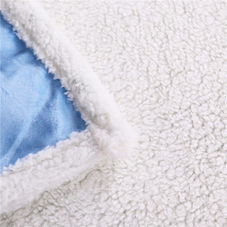 Close-up of soft plush blanket showcasing cozy Sherpa fleece and smooth blue velvet lining.