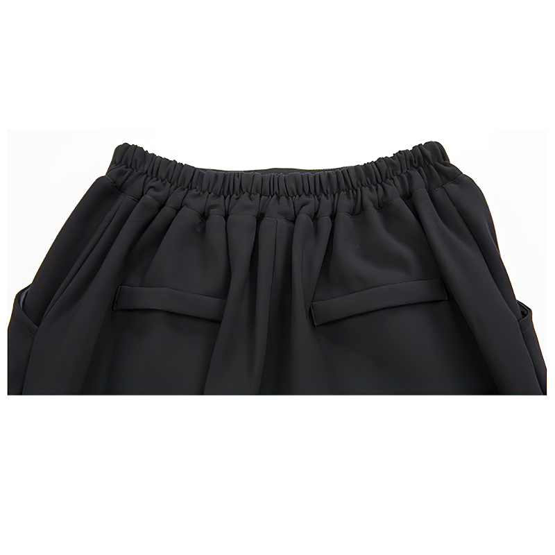 Close-up of high waist black women's harem pants featuring an elasticated waistband and side pockets.