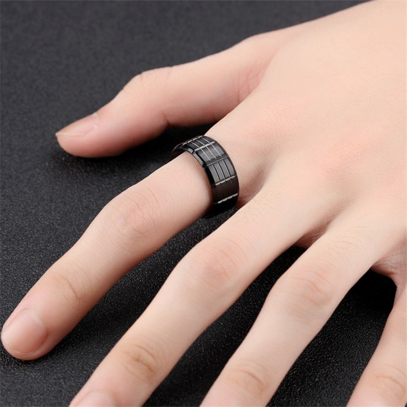 Black stainless steel ring on a hand, showcasing its unique pattern and stylish design for alternative fashion.