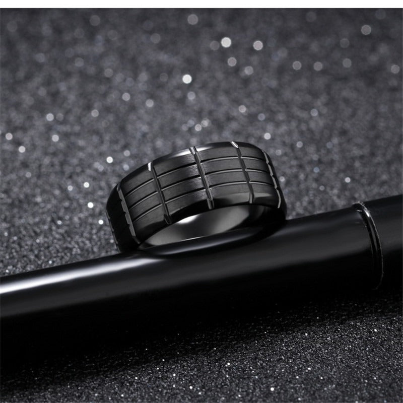 Black stainless steel ring with sleek pattern, perfect for alternative fashion and rocker style jewelry lovers.