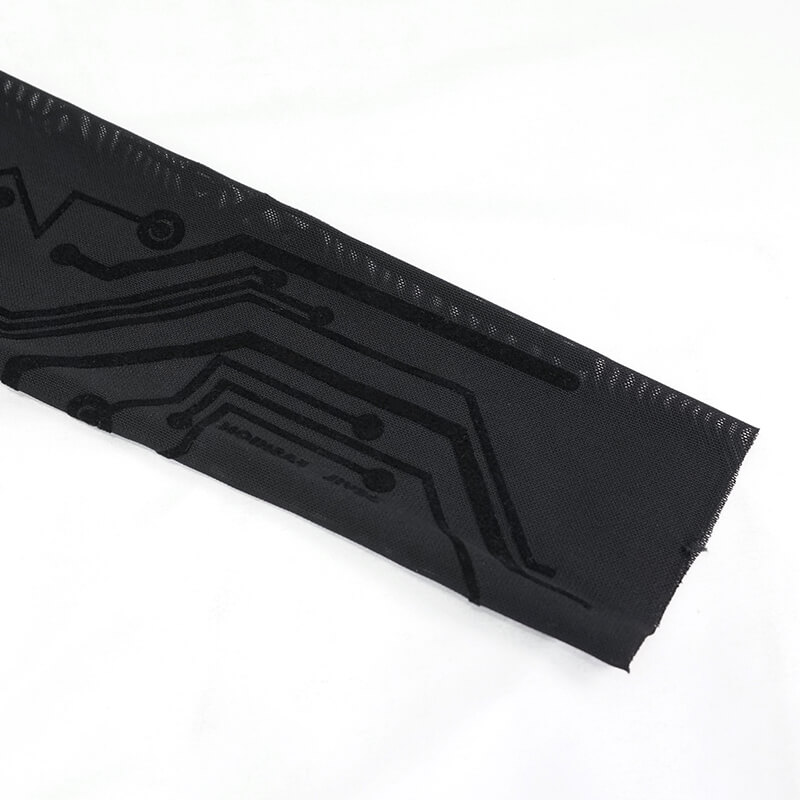Close-up of black cyberpunk fabric with futuristic circuit pattern, perfect for stylish long sleeve tops.