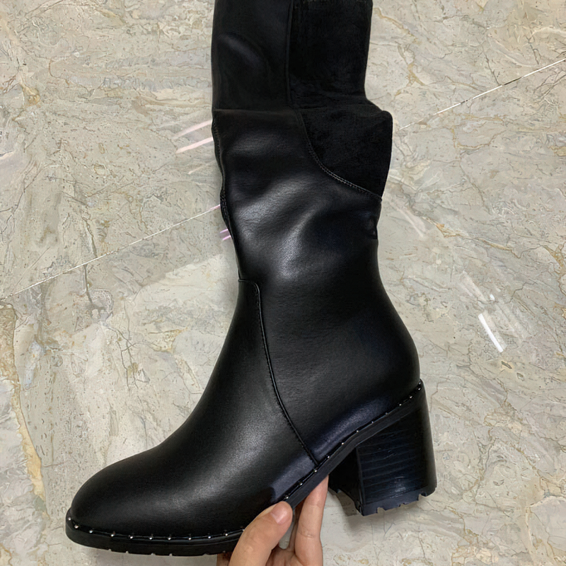 Black genuine leather knee-high women's boots with round toe and stylish heeled design.