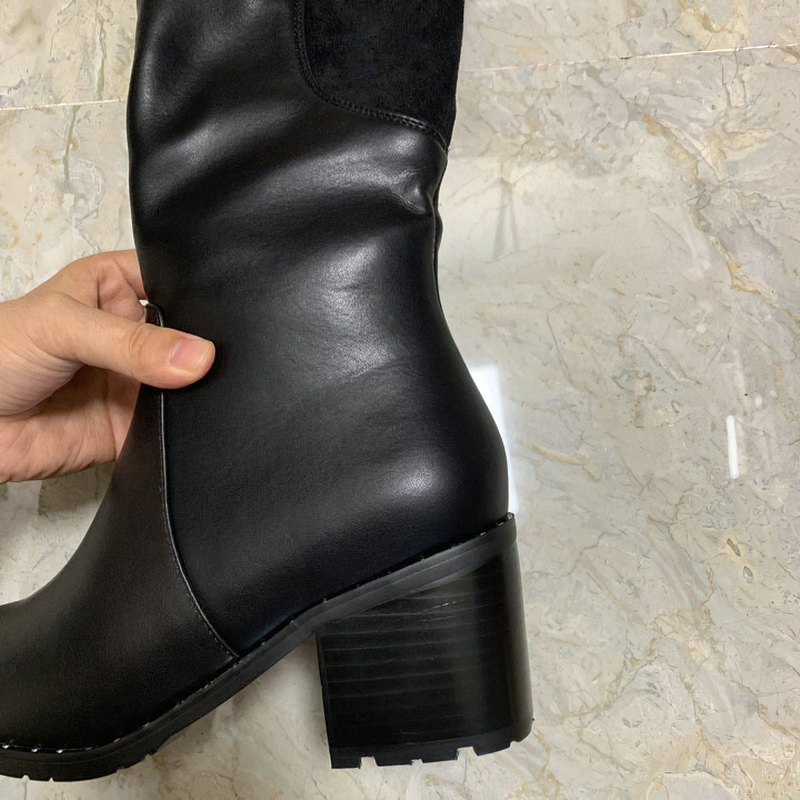 Black leather women's knee-high boot showing stylish design and sturdy heel, perfect for casual elegance.