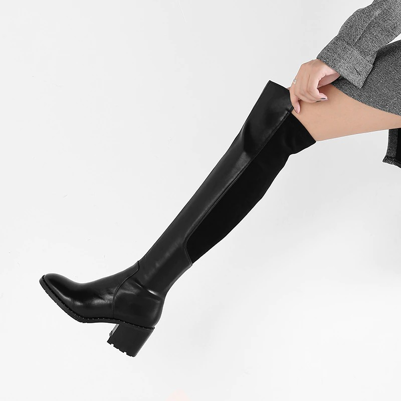 Black knee-high women's boots featuring a stylish round toe and comfortable flat sole, perfect for casual elegance.