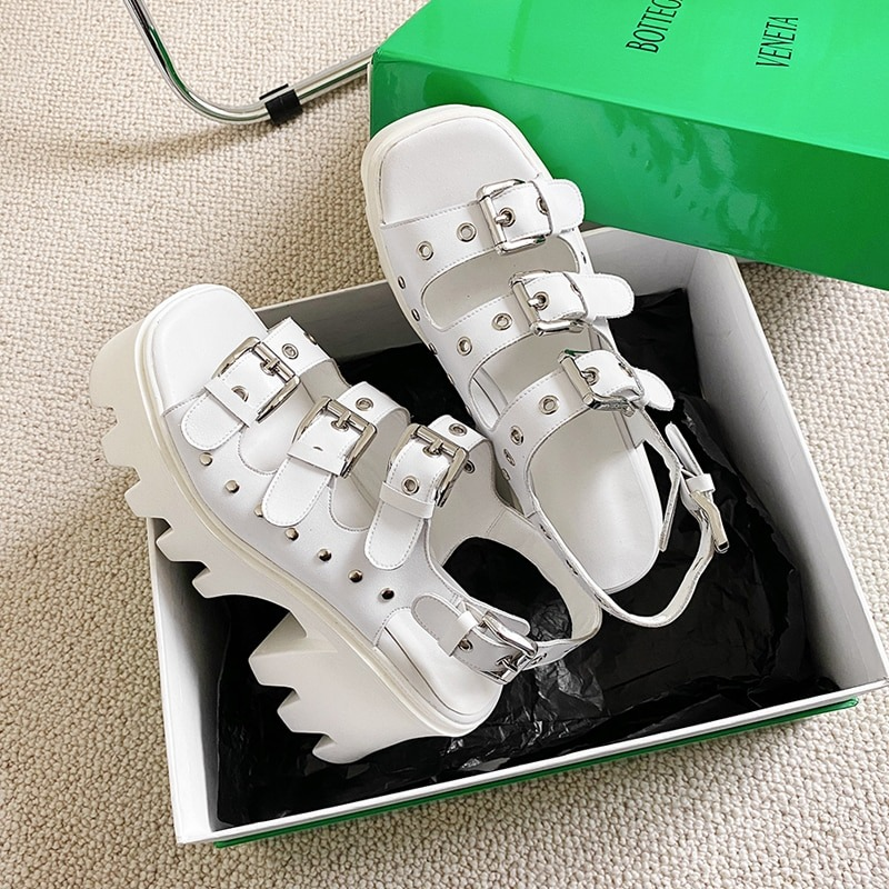 White platform sandals with buckles and rivets in a green box, perfect for summer punk outfits.