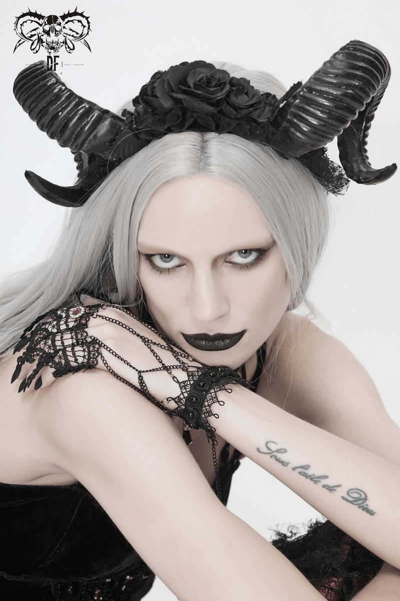 Stunning woman in a black gothic devil horn headdress with roses, showcasing a bold gothic fashion statement.