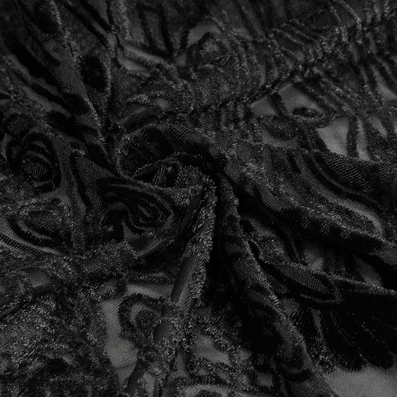 Close-up of luxurious black lace fabric showcasing intricate gothic designs and textures.