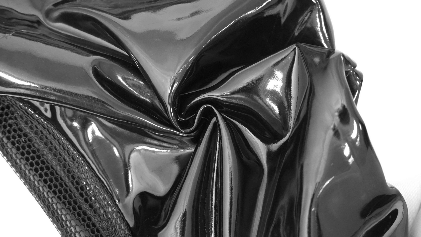 Shiny black PU leather fabric, gothic punk style texture close-up.