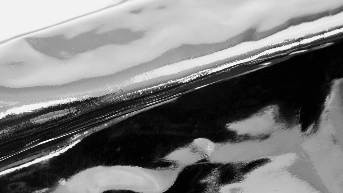 Close-up of glossy black PU leather fabric used in men's Gothic punk pants.