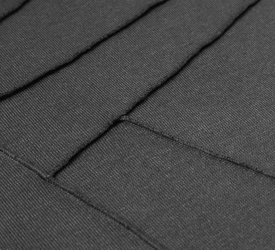 Close-up of the textured fabric of a black gothic punk hoodie, showcasing stylish seams and design.