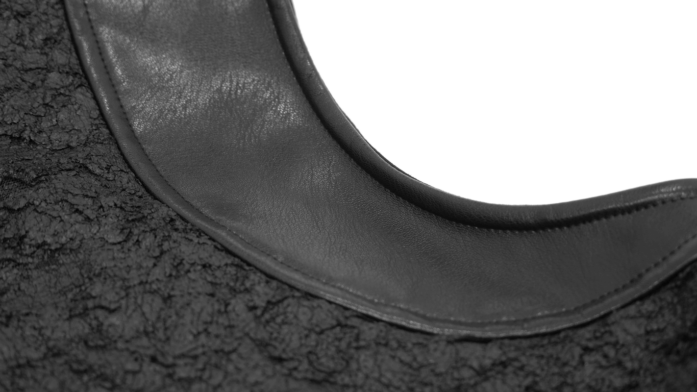 Close-up of gothic black hooded top neckline showcasing textured fabric and sleek leather trim.