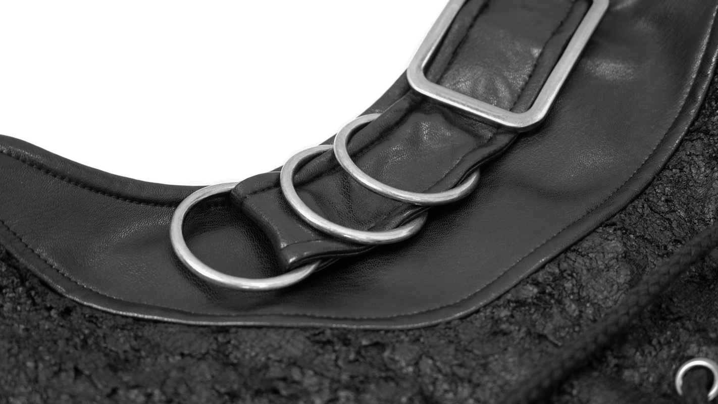 Close-up of the neckline detailing on a black hooded sleeveless top featuring stylish metallic rings.