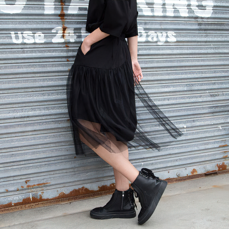 Model wearing black irregular half-length trousers with mesh, perfect for alternative fashion. Rockstar style with a gothic twist.