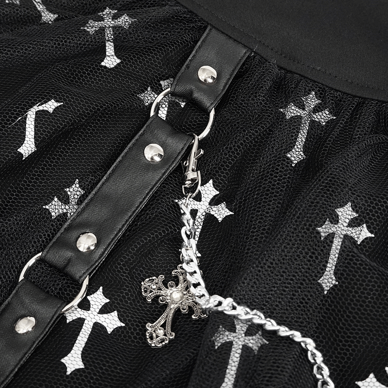Detailed view of women's black knitted skirt with white crosses print and silver chain embellishment.