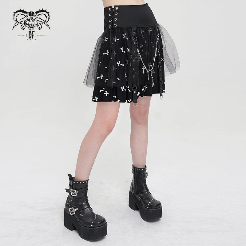 Punk black knitted skirt with white crosses print, featuring side straps and a chain, styled with edgy ankle boots.