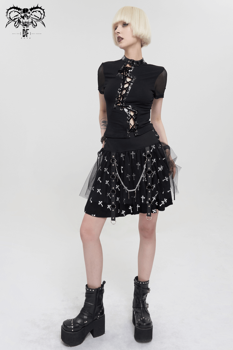 Punk women's black knitted skirt with white crosses print, paired with a stylish cropped top and chunky boots.