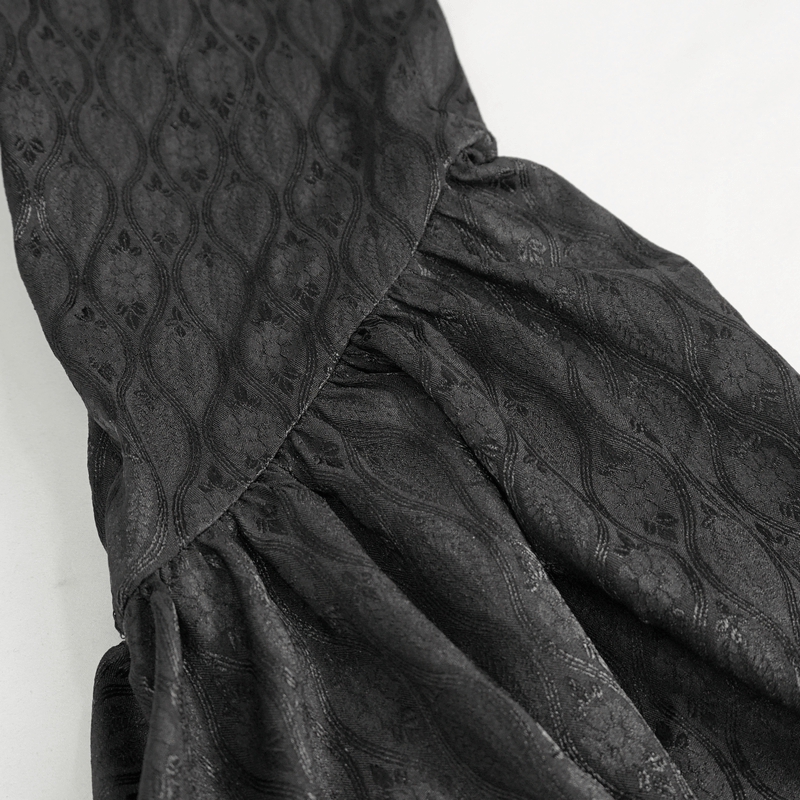 Close-up of the elegant textured fabric of a black flared sleeves goth long coat for women.