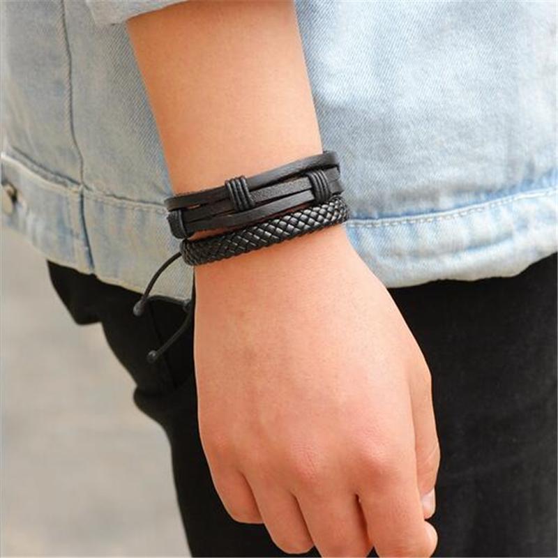 Stylish black leather bracelet set of 5 perfectly complementing a rock look on a man's wrist.