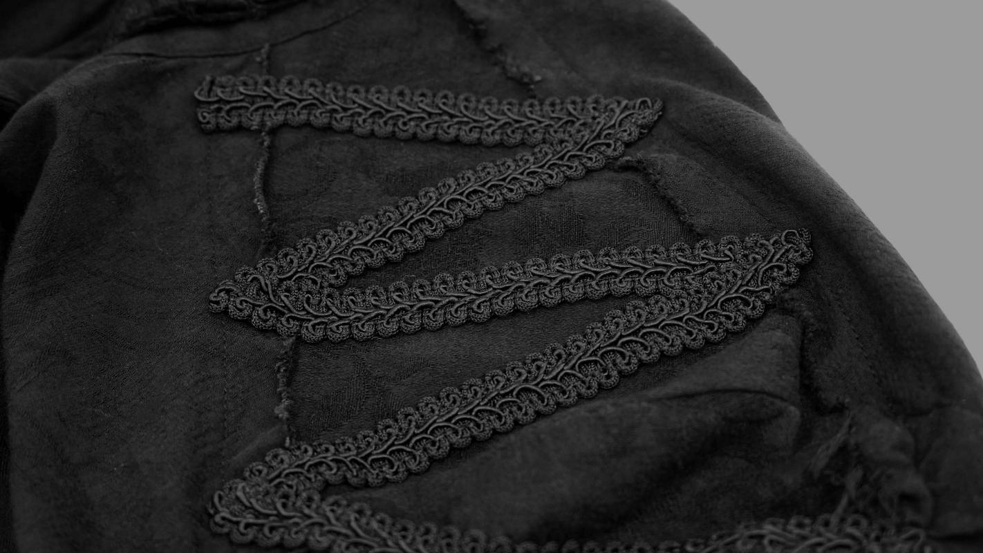 Close-up of the intricate black lace detailing on a vintage gothic shirt's sleeve.