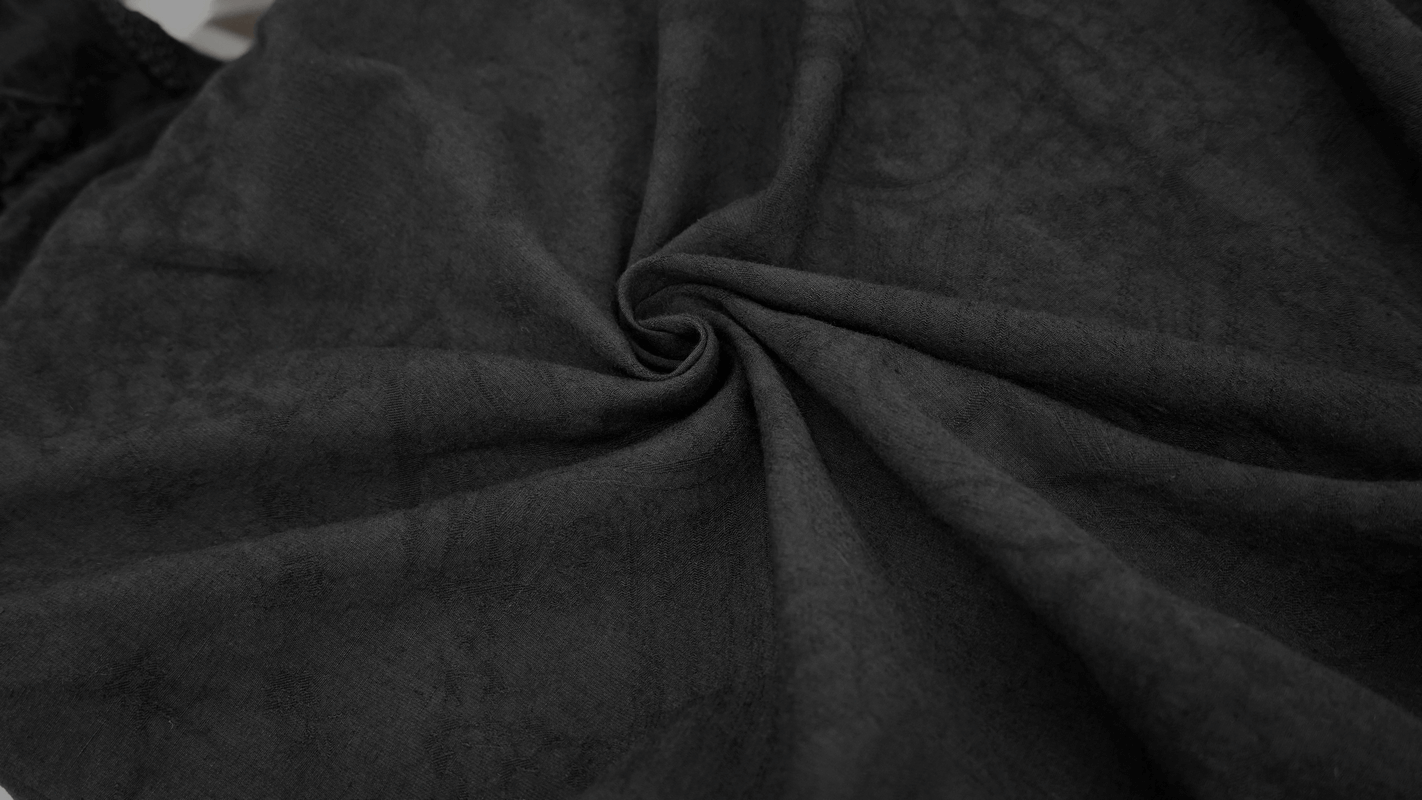 Close-up of soft, black fabric showcasing texture, perfect for gothic style clothing and stylish vintage shirts.