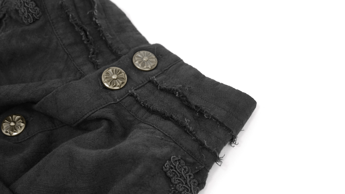 Close-up of vintage black shirt sleeve with decorative buttons and frayed edges for gothic style fashion.