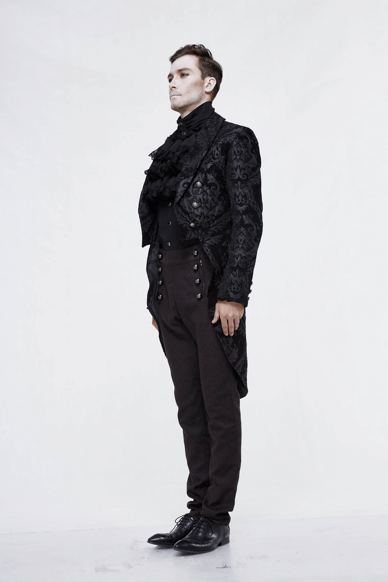Stylish man in a black long trench coat with vintage design and silver buttons, showcasing gothic fashion.