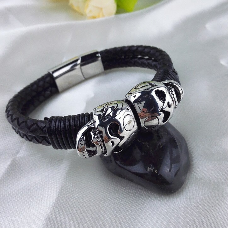 Black braided leather bracelet with stainless steel skulls, perfect punk rock style accessory for men.
