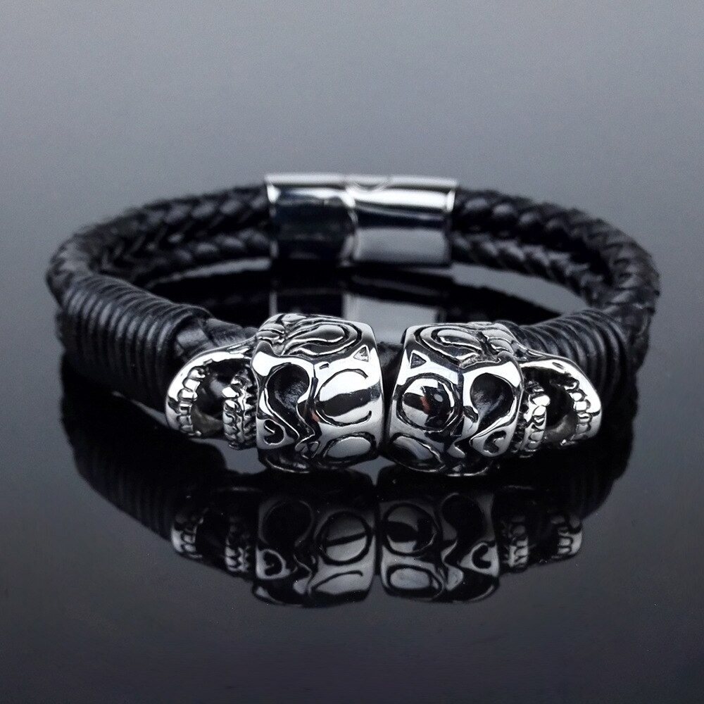 Black men's braided leather bracelet featuring stainless steel skulls for a punk rock gothic style.