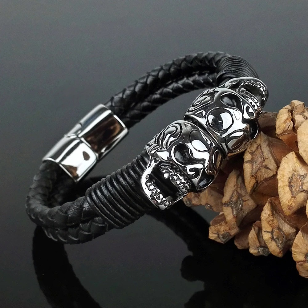Black men's braided leather bracelet with stainless steel skulls, perfect for punk rock style outfits.