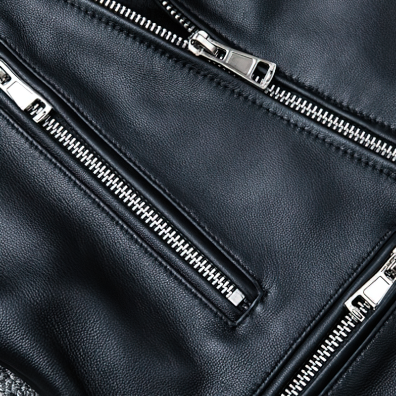 Close-up of a black men's genuine leather jacket with sleek silver zippers and pockets.