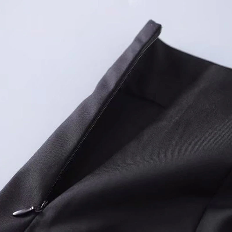 Close-up of the zipper on a black mini skirt, showcasing sleek design and quality fabric for vintage style.