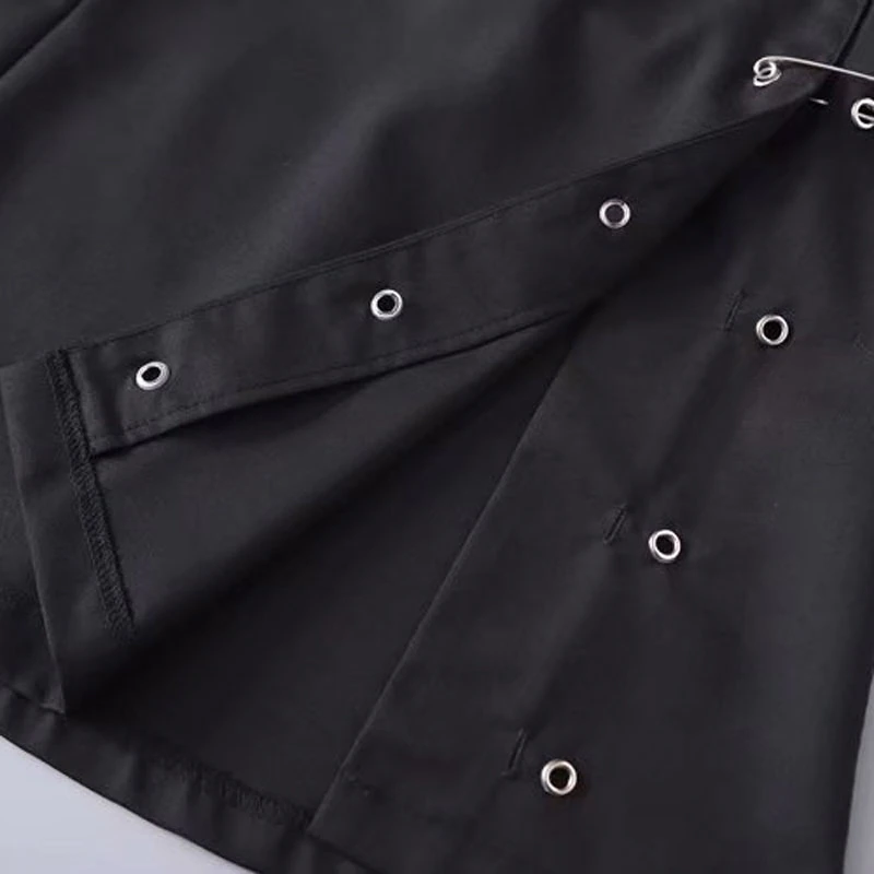 Close-up of black mini skirt showing decorative side pins and eyelets for a vintage and elegant look.
