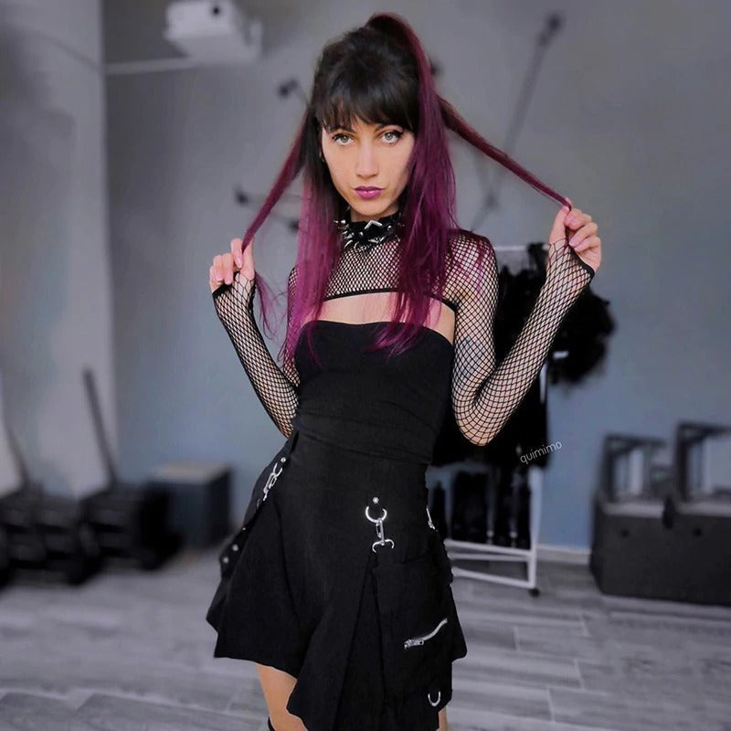 Model showcasing a black mini skirt with metallic details and fishnet sleeves, exuding stylish streetwear vibes.