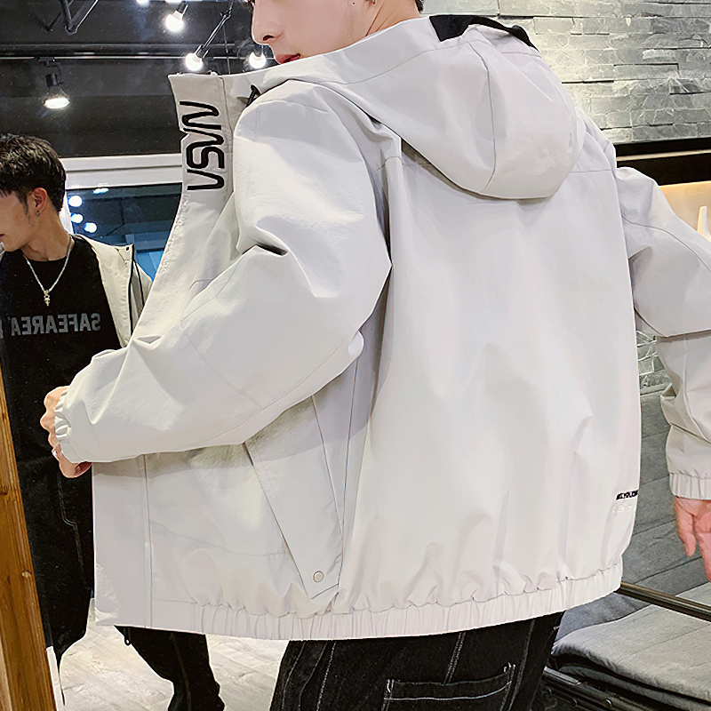 Stylish man showcasing a light gray cargo jacket with hood and pockets, perfect for casual rock-inspired outfits.