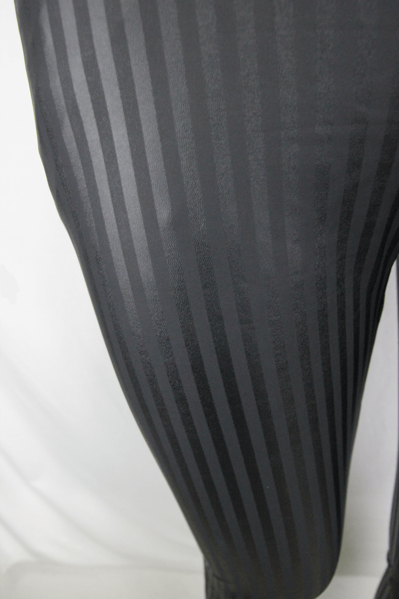Close-up of fitted men's black pants with vertical stripes, showcasing gothic retro style and quality fabric.