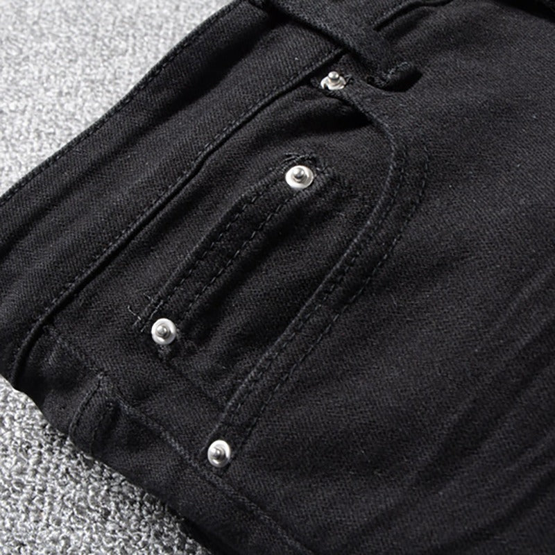 Close-up of black patchwork biker jeans showcasing pockets and stitching details for stylish motorcycle fashion.