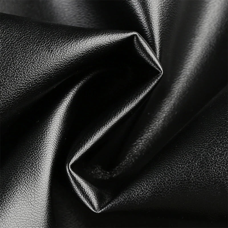 Close-up of black PU leather fabric, showcasing its smooth texture and shine for stylish apparel.