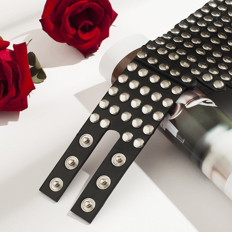 Black PU leather choker with rivets, styled among red roses, perfect for gothic fashion and edgy accessories.