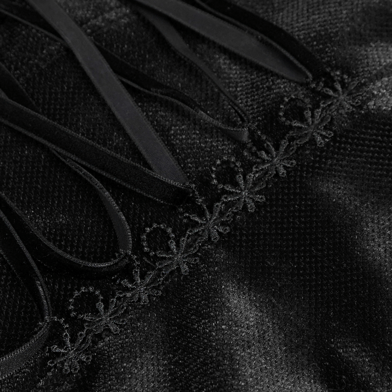 Close-up of black lace ruffle and velvet fabric showcasing elegant gothic details on women's blouse.